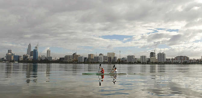 Kayakers paddle on the Swan River past the Perth city skyline, Australia.