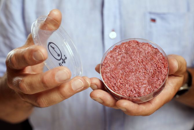 Professor Mark Post holds the world's first lab-grown beef burger during a launch event in west London.
