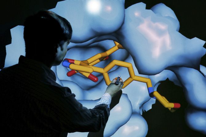 Scientist Nathan Brown moves a 3D model of a HSP90 protein on a screen at the Institute of Cancer Research in Sutton.