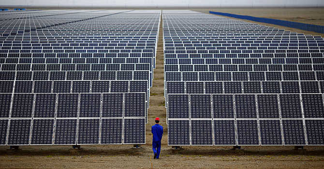 A worker inspects solar panels at a solar Dunhuang, 950km northwest of Lanzhou, Gansu Province, China. The two countries have also agreed to launch an initiative on clean energy.