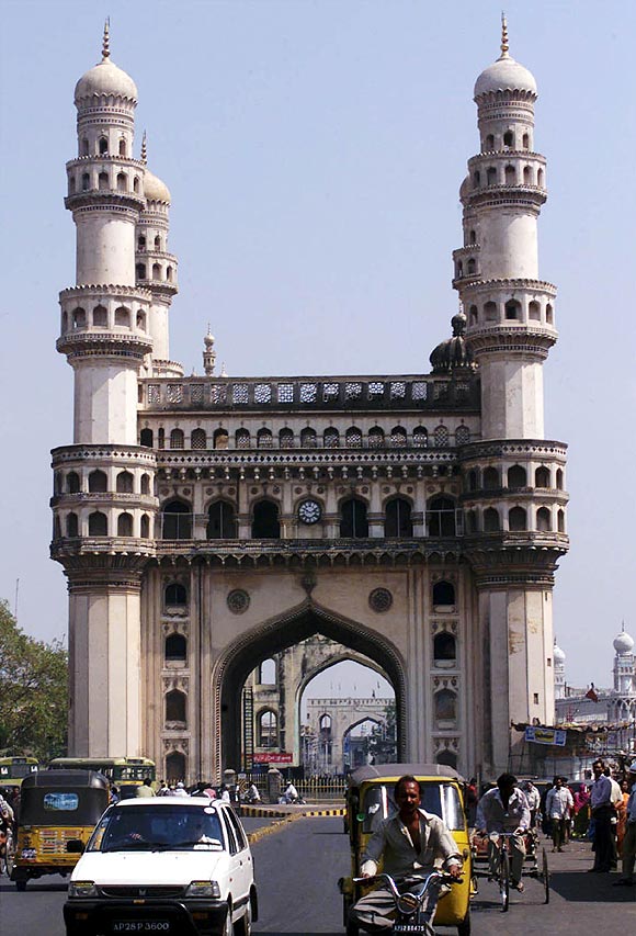 Residents of Hyderabad drive past the 'Charminar', the city's best known monument.
