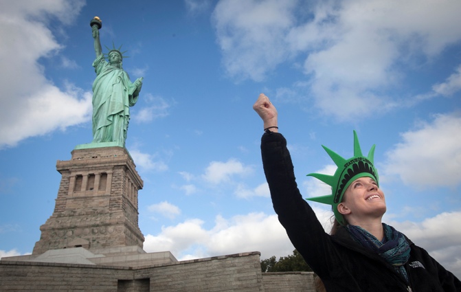 Bethany McNew, 24, from Tampa, mimics the pose of the Statue of Liberty as she poses for a photo on Liberty Island in New York.