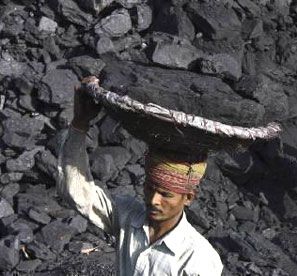 A labourer carries coal in a basket to load it in a truck. Photograph: Ajay Verma/Reuters