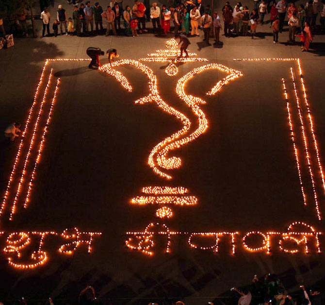 People light earthen lamps in the shape of Hindu god Ganesh, the deity of prosperity, on the eve of Diwali.