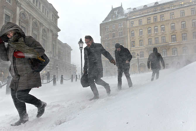 People struggle against wind and drifting snow in Stockholm, Sweden.