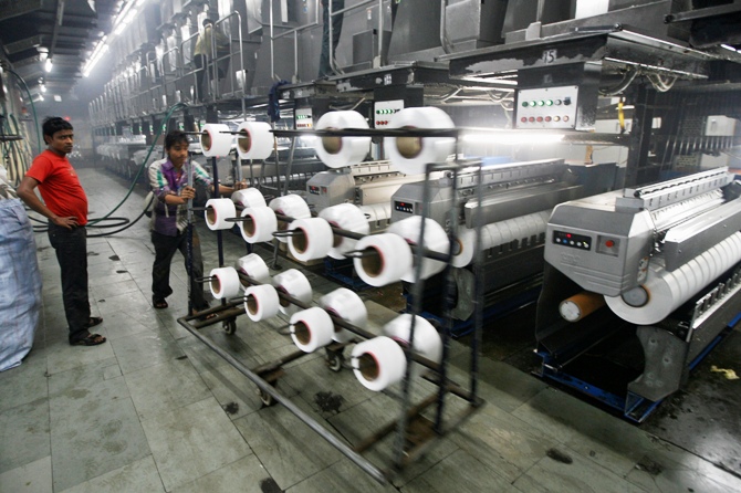 A worker pushes a trolley inside a nylon yarn manufacturing factory at Palsana village on the outskirts of Surat, Gujarat.