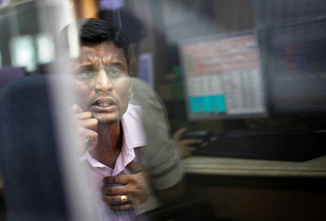 A broker looks at a computer screen as he talks on a phone at a stock brokerage firm in Mumbai.