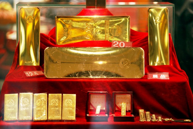 Gold bars of various sizes can be seen in a display case.