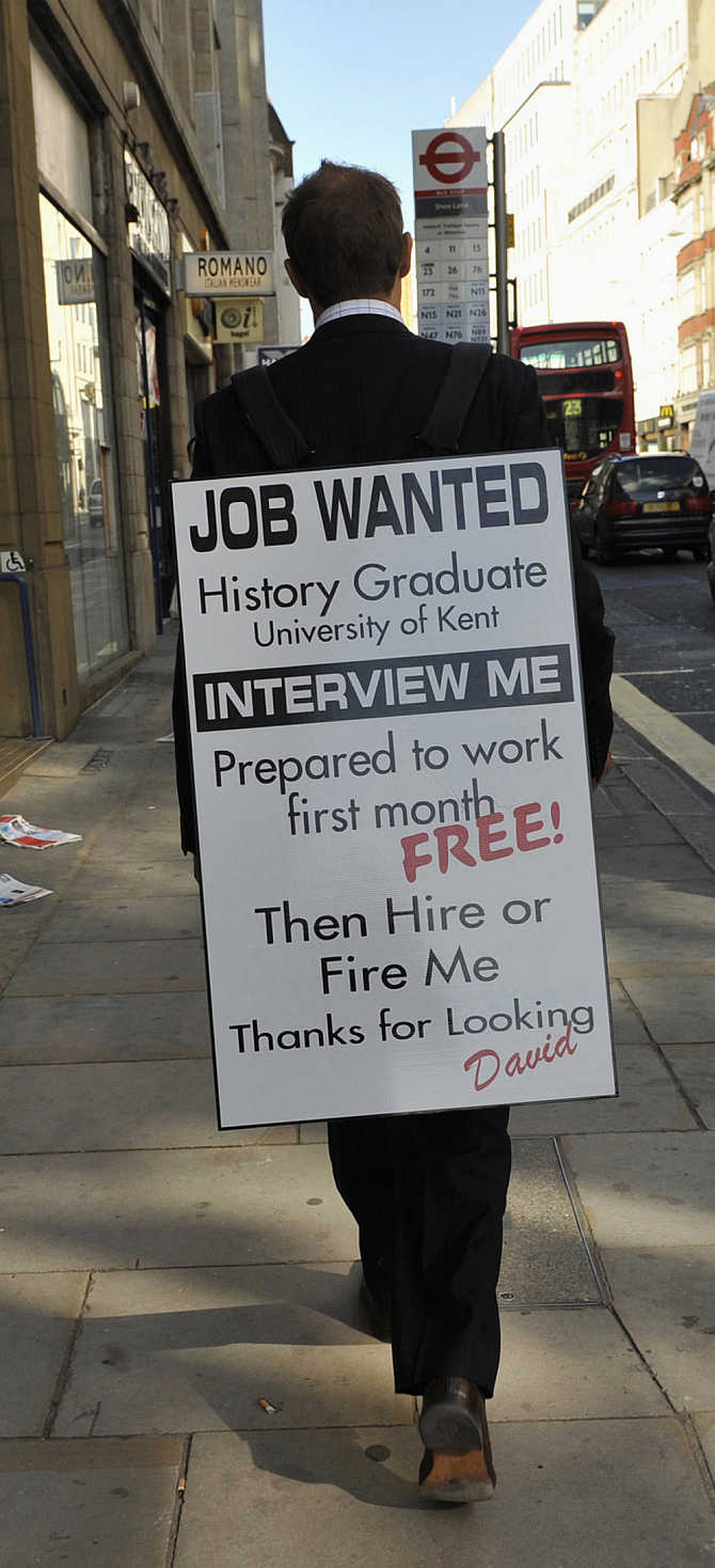 Jobless university graduate David Rowe wears a sandwich board advertising his search for employment as he walks along Fleet Street in central London.