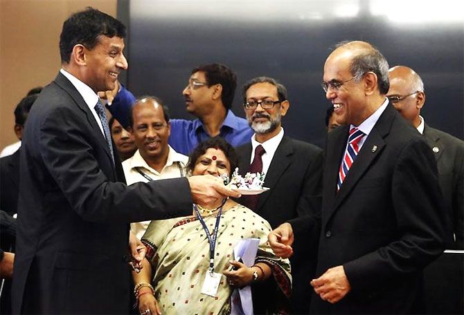 Dr Raghuram Rajan, left, then the newly appointed governor of the Reserve Bank of India, offers sweets to the outgoing governor Dr Duvvuri Subbarao. Photograph: Danish Siddiqui/Reuters