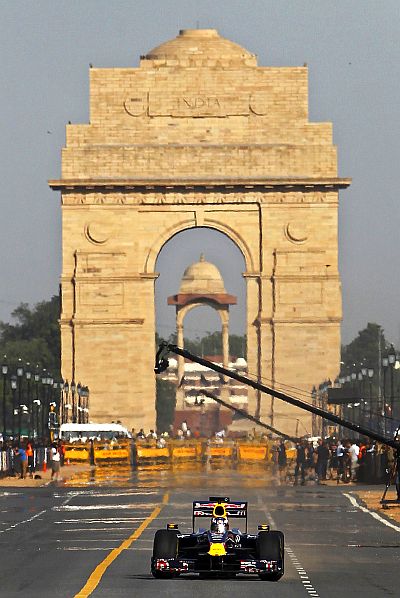 Red Bull Formula One reserve driver Daniel Ricciardo of Australia drives in front of the India Gate during his team's road show in New Delhi.