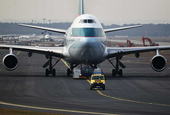 An airport apron controller vehicle is pictured in front of a Cathay Pacific Boeing B747-400 Aircraft on the runway at Frankfurt's airport, Germany.