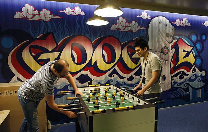 Google's employees play table soccer at a recreational area at their Singapore office.