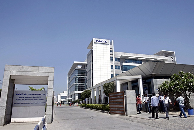 People walk in front of the HCL Technologies Ltd office at Noida, on the outskirts of New Delhi.