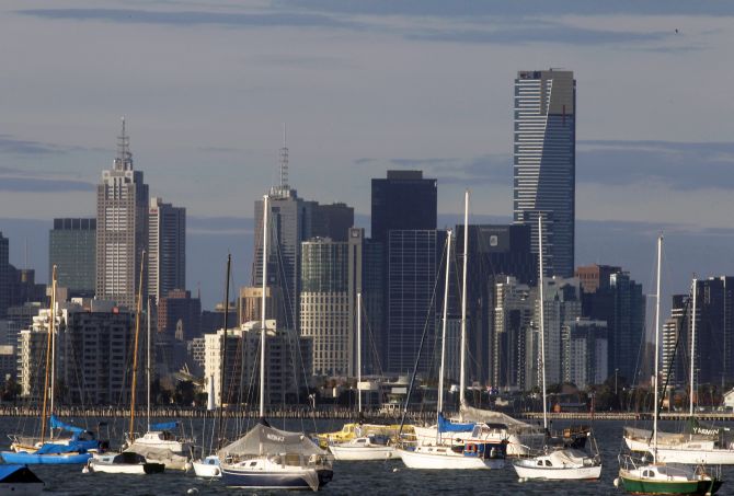 Sailboats and yachts are seen in front of the Melbourne skyline.