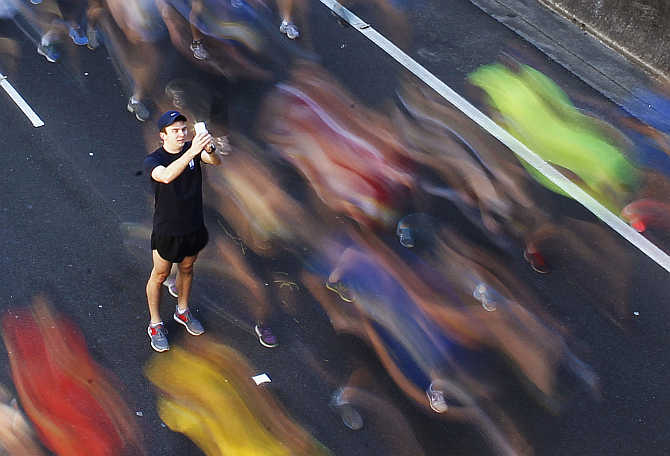 A man takes a picture of himself among participants during the annual City2Surf fun run in central Sydney, Australia.