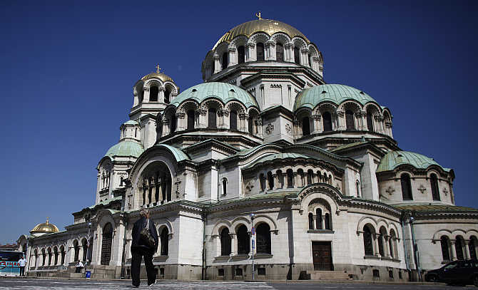 A woman walks past the golden-domed Alexander Nevski cathedral in central Sofia, Bulgaria.