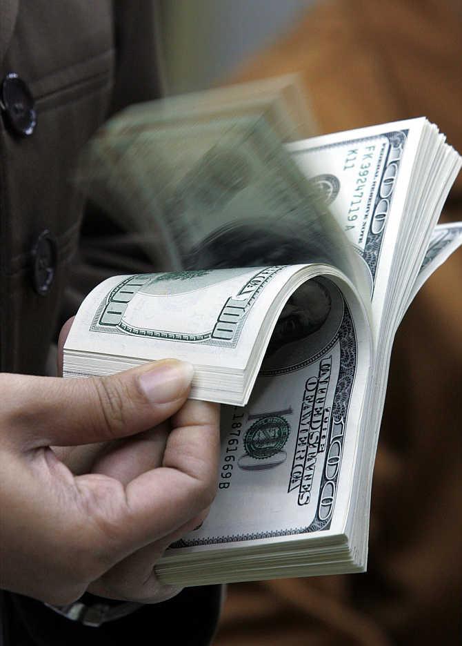 A man counts dollar notes at a money changer in Jakarta, Indonesia.