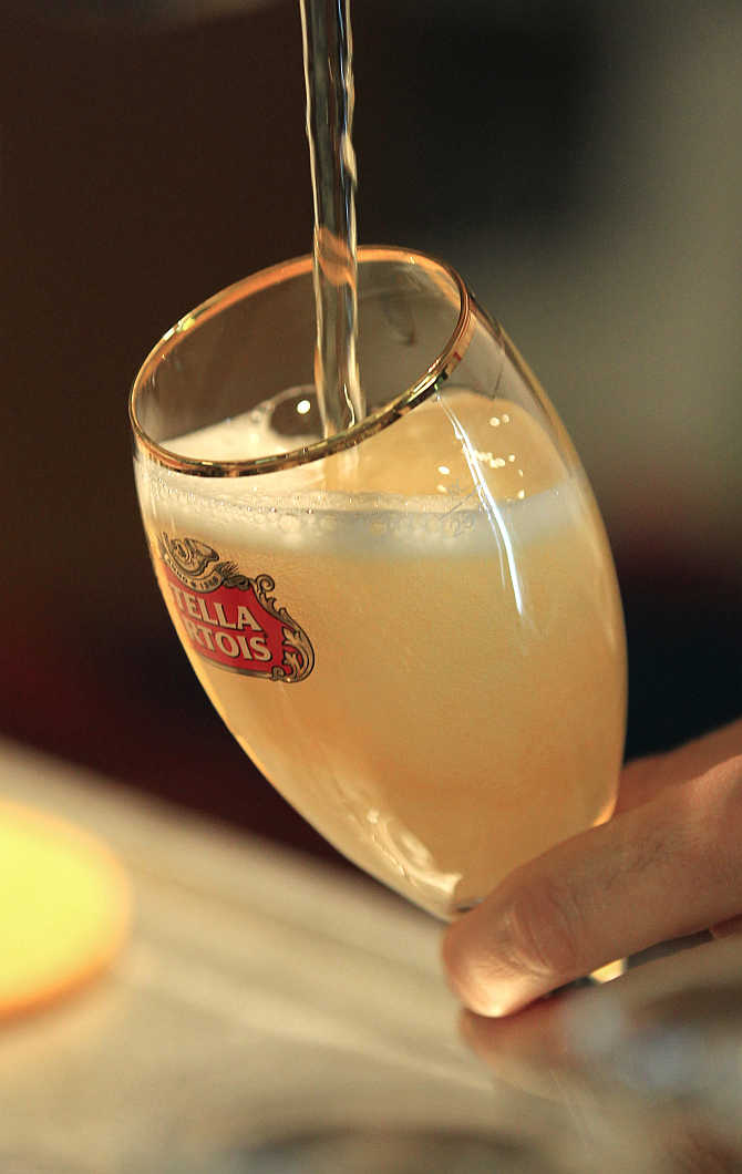 A waiter serves a glass of beer ahead of an Anheuser-Busch InBev shareholders meeting in Brussels, Belgium.