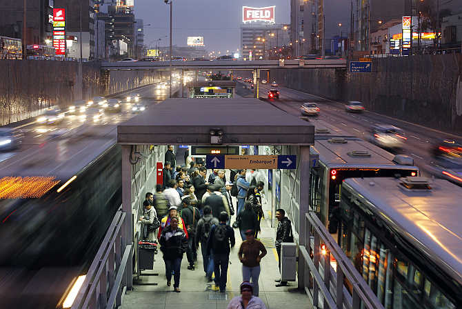 Commuters queue at one of Metropolitano bus stations in Lima, Peru.
