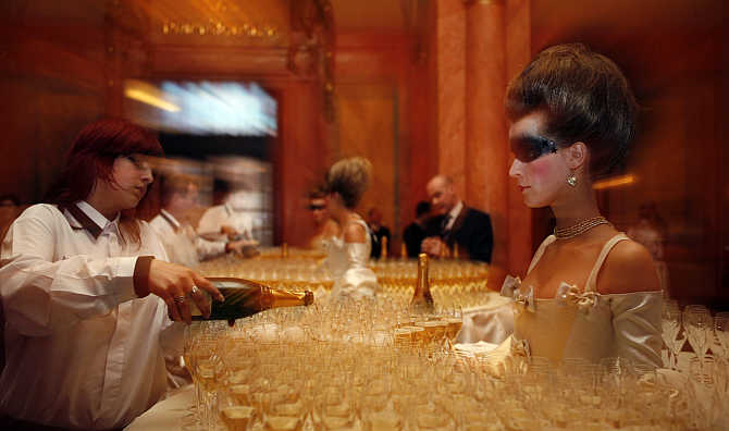 A waitress pours champagne into glasses at the foyer of Municipal House before the final of the Elite Model Look competition in Prague, the Czech Republic.