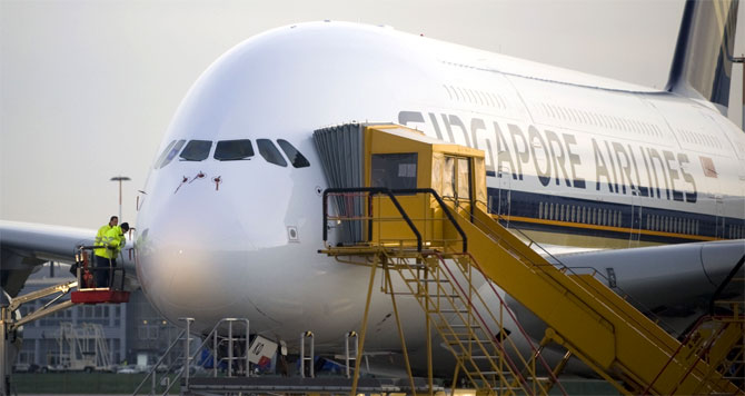 Airbus employees work at an Airbus A380 aircraft of 'Singapore Airlines' at the Airbus facility in Finkenwerder near Hamburg.