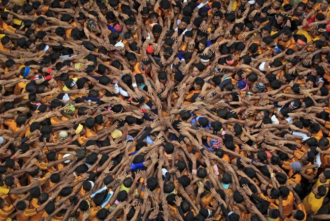 Devotees form a human pyramid to break a clay pot containing curd during the celebrations to mark the Hindu festival of Janmashtami in Mumbai, India