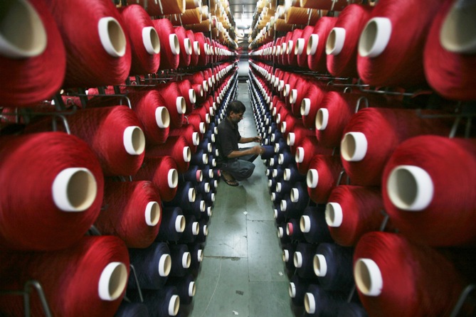 An employee works at the production line of a carpet manufacturing factory in Jammu.