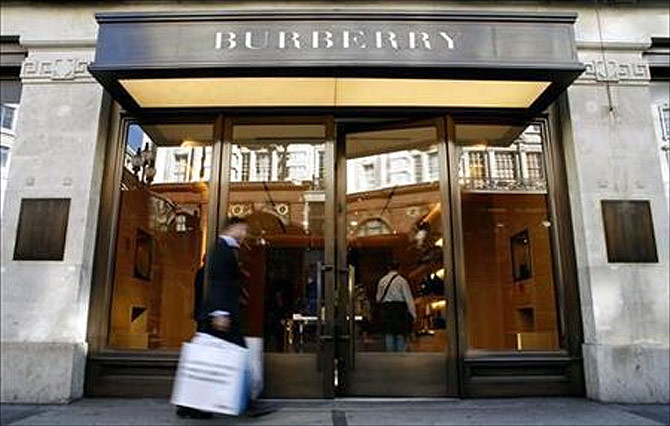 A customer walks in front of a Burberry store.