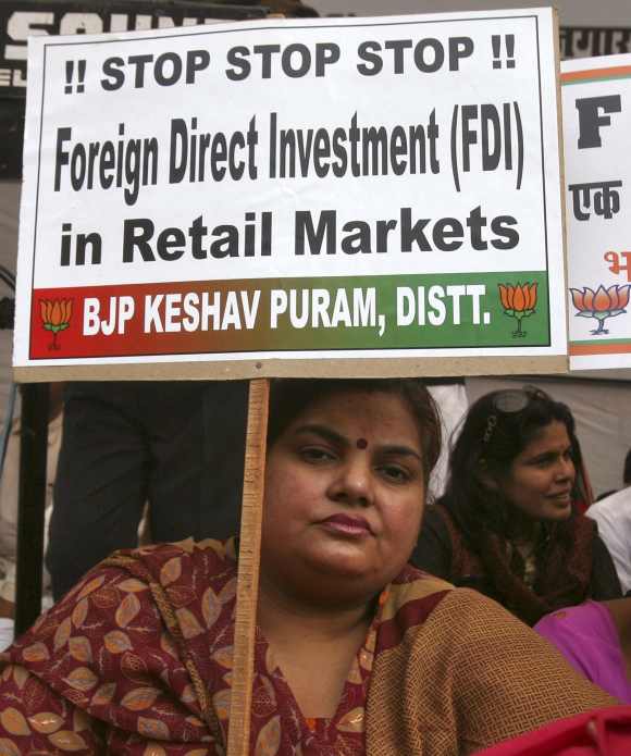 An activist from India's main opposition Bharatiya Janata Party (BJP) holds a placard while taking part in a protest against government's decision to allow Foreign Direct Investment (FDI) in the retail sector.