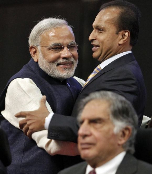 Gujarat's chief minister Narendra Modi (L) and Anil Ambani, chairman of Reliance Group, embrace as Ratan Tata, chairman Emeritus of Tata group, looks on.