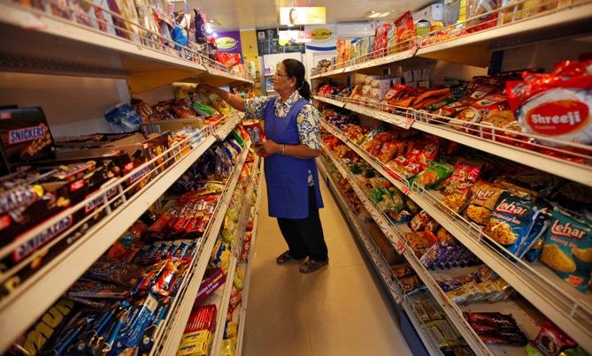 A worker arranges food packets inside a retail store in Kolkata. 