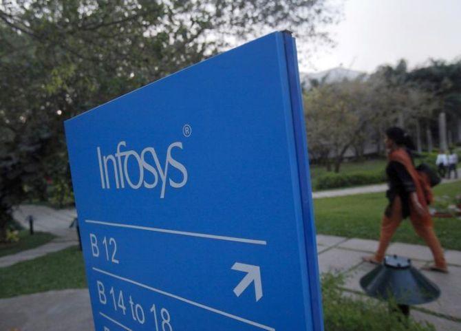 An employees walks past a signage board in the Infosys campus at the Electronics City IT district in Bangalore.