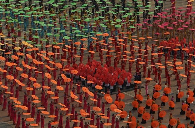 People dance with umbrellas during a celebration for the New Year of the Dai minority in Xishuangbanna, Yunnan province, April 14, 2014. 