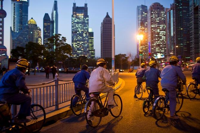 Construction workers ride along a street at central Shanghai.