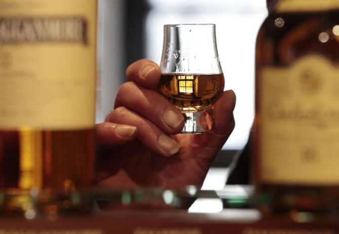 A man holds a glass of whisky in the visitors centre of the Diageo-owned Dalwhinnie Distillery in Dalwhinnie.