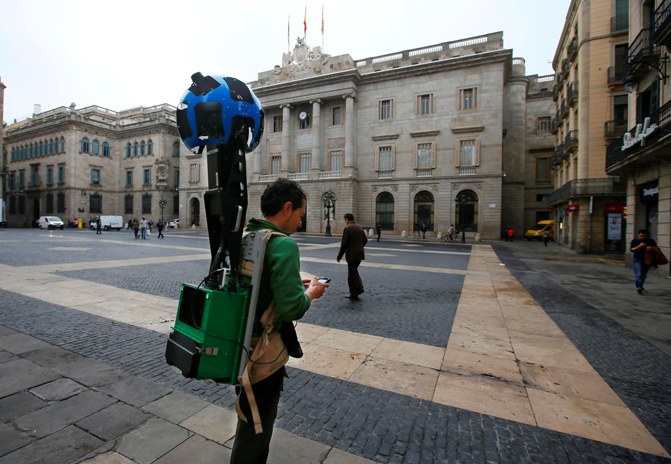 A man takes pictures with a Google Street View Camera in Plaza Sant Jaume in front of the town hall of Barcelona April 8, 2014.