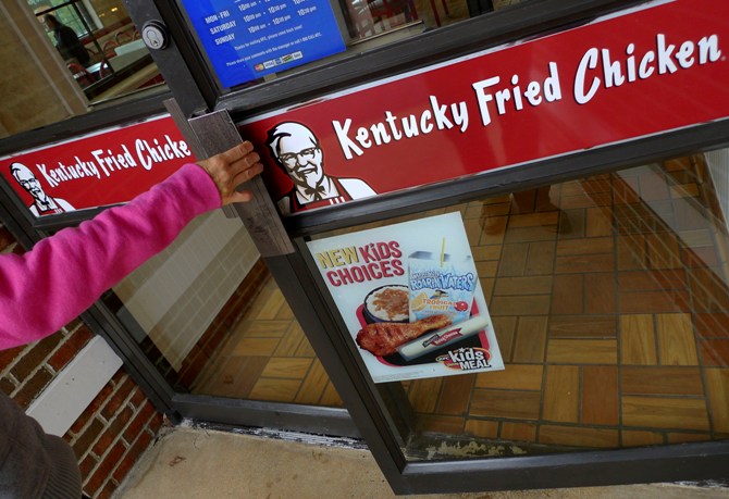 A customer enters a Kentucky Fried Chicken restaurant.