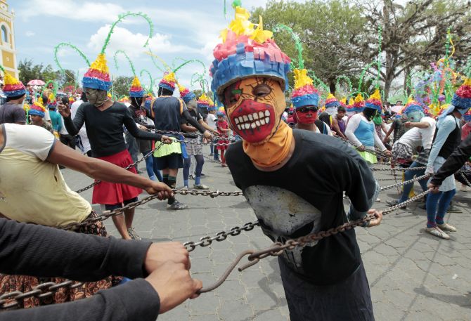 A masked man takes part in a Good Friday procession during Holy Week celebrations in Masatepe.