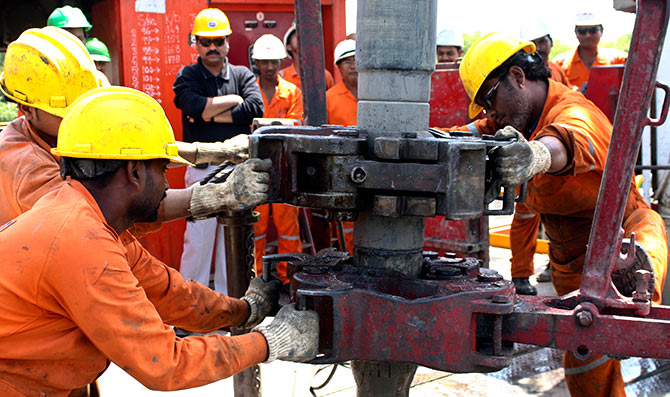 Engineers of Oil and Natural Gas Corp (ONGC) work inside the Kalol oil field in the western Indian state of Gujarat.