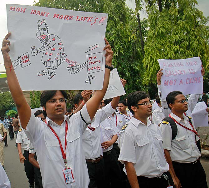 An employee of Kingfisher Airlines holds a poster during a protest against the company near the domestic airport in Mumbai 