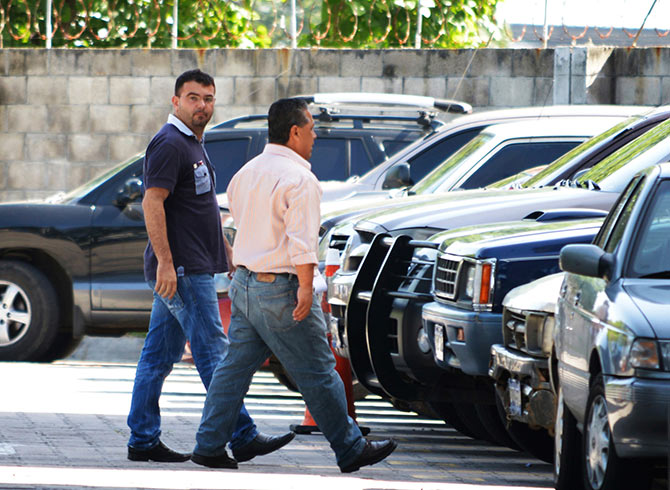 Spanish priest Antonio Rodriguez (L) walks into the Central Bureau of Investigation with a police investigator in San Salvador.
