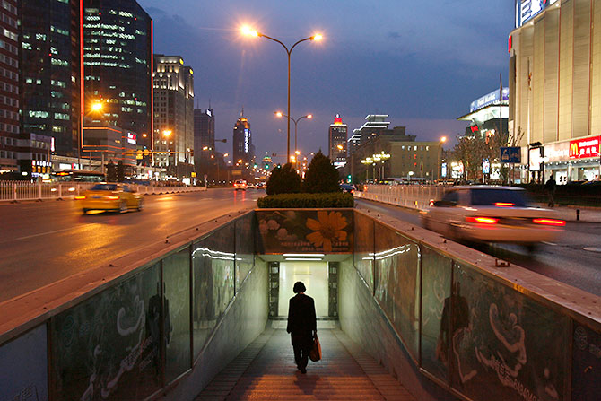 A woman walks into a subway in the central business district of Beijing.