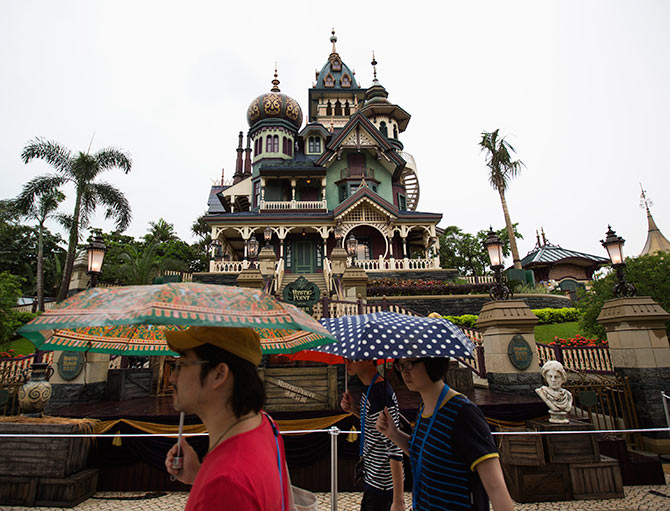 Journalists walk past a building at Mystic Point Grand in Hong Kong Disneyland.