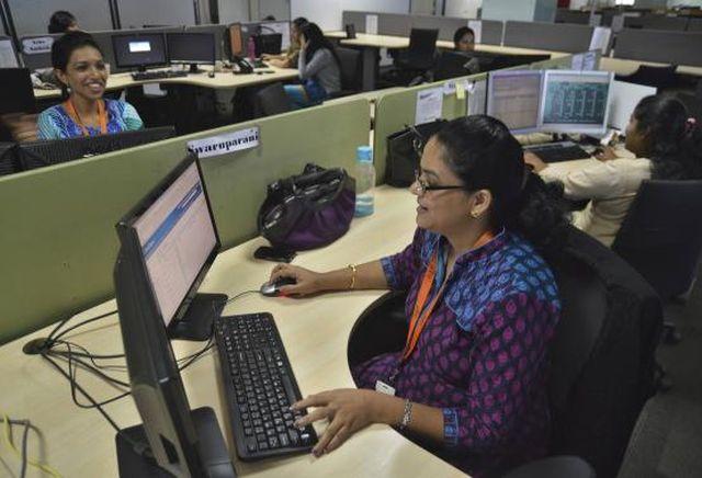 Employees of ISGN work at their stations inside the company headquarters in Bangalore June 11, 2014. 