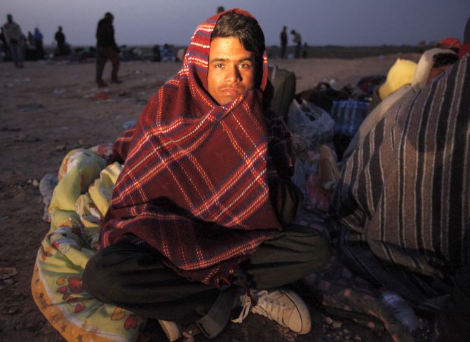 A Bangladeshi migrant workers sits in front of a refugees camp.