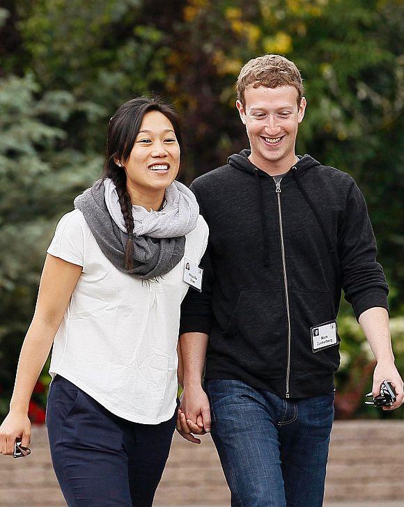 Facebook CEO Mark Zuckerberg walks with his wife Priscilla Chan