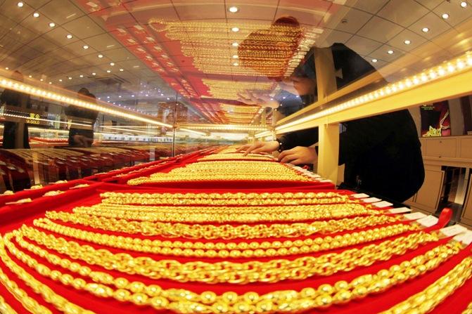 A sales assistant arranges gold necklaces at a store in Lianyungang, Jiangsu province.