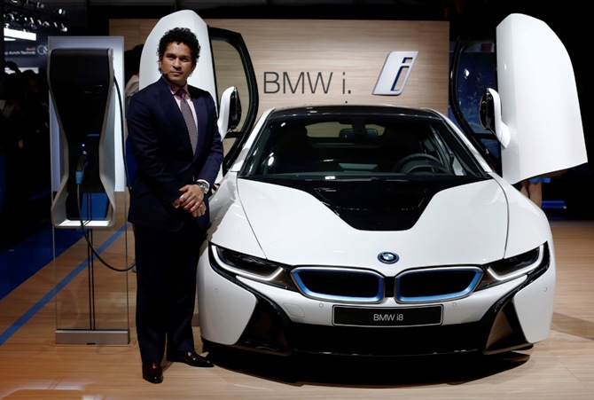 Retired cricketer Sachin Tendulkar poses with BMW's i8 hybrid car during its launch at the Indian Auto Expo in Greater Noida, on the outskirts of New Delhi, February 5, 2014.