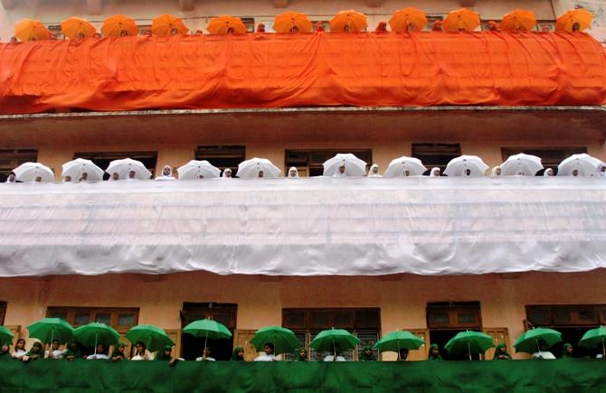 School children decorate their school building in tri-colours of India's national flag ahead of the country's Independence Day celebrations in Ahmedabad.